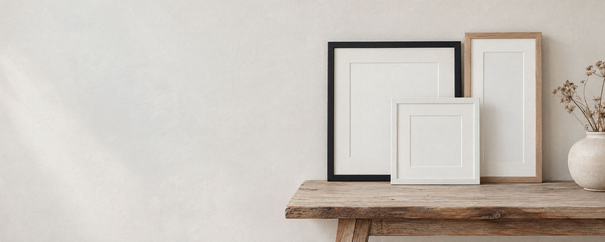 Black, white and oak frames with white mounts on a wooden bench