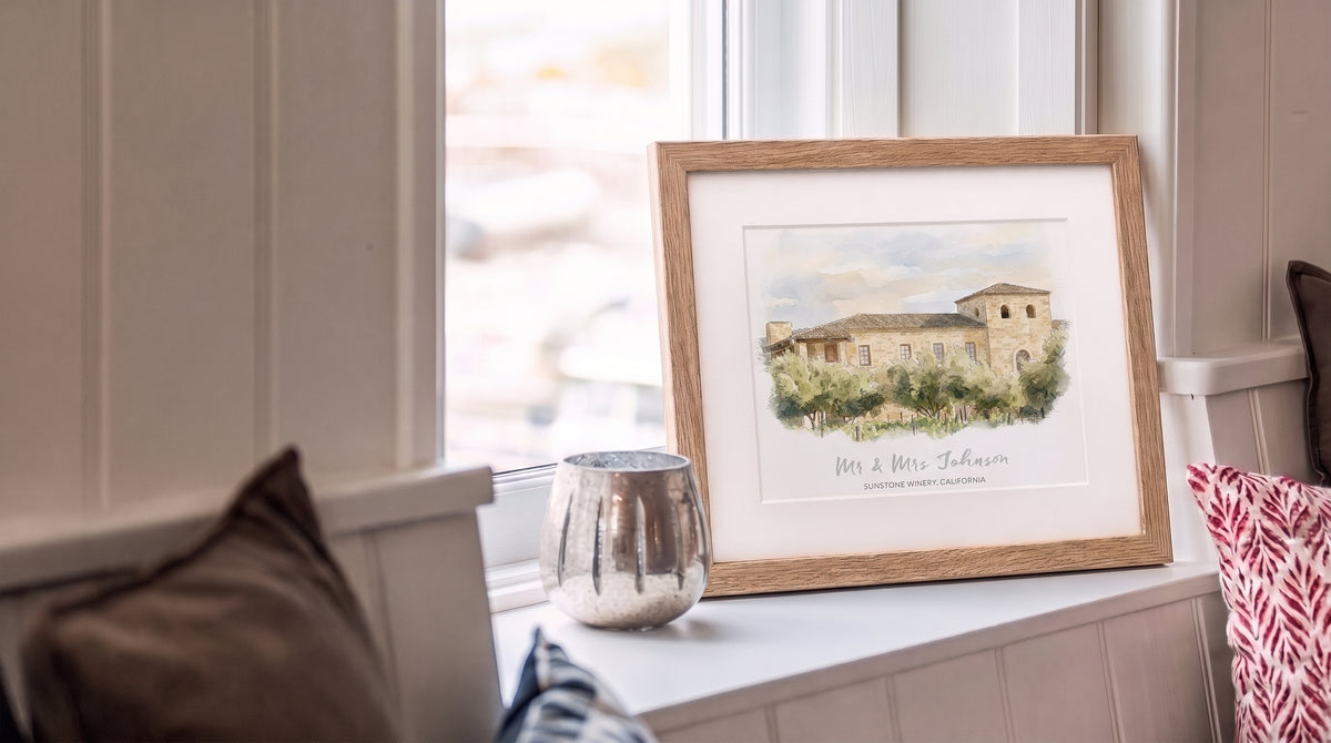 Framed watercolour of a wedding venue on a windowsill